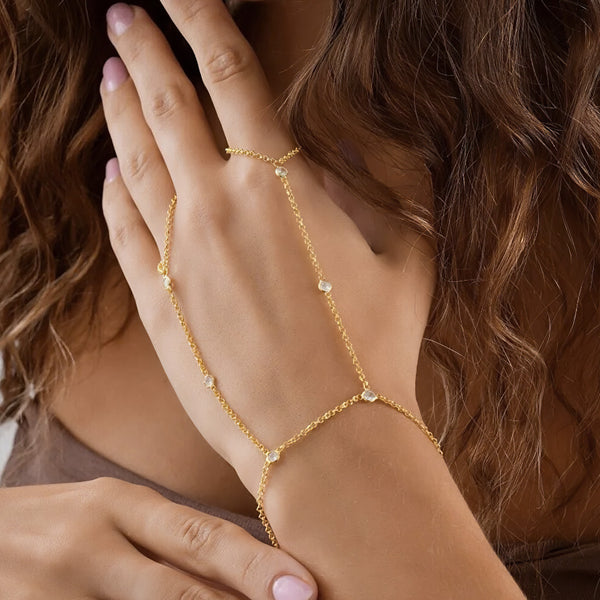 Gold chain bracelet on a wrist with a blurred background