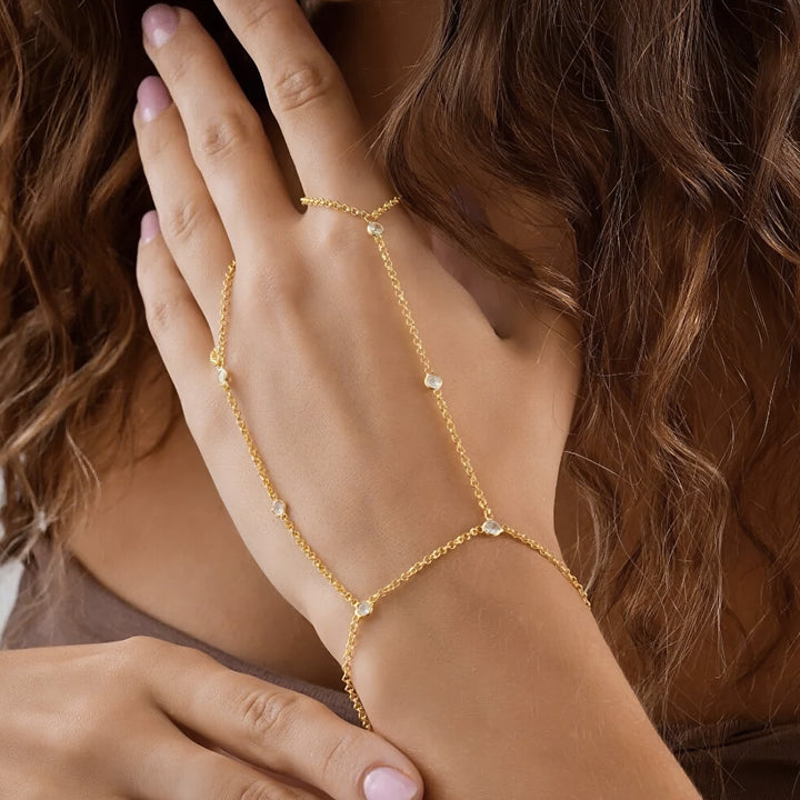 Gold chain bracelet on a wrist with a blurred background