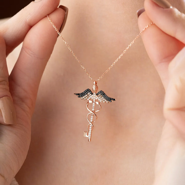 Rose gold necklace with a unique pendant held by hands against a neutral background