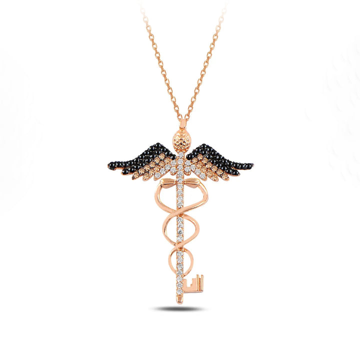 Rose gold medical symbol necklace with black and white gemstones on a white background
