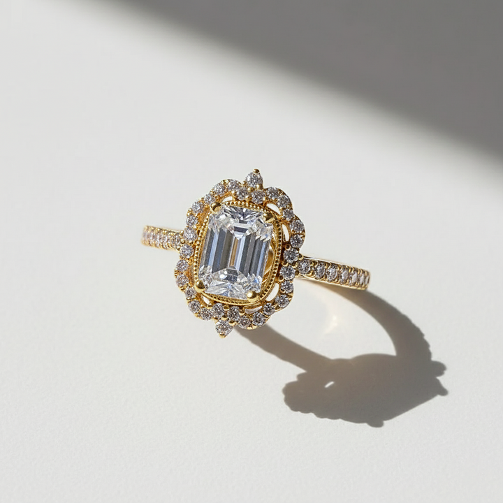 Gold ring with emerald-cut diamond on a light background