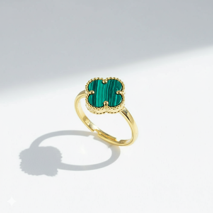 Gold ring with a green gemstone on a white background