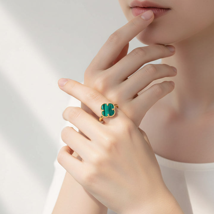 Hand wearing a green malachite ring with a neutral background