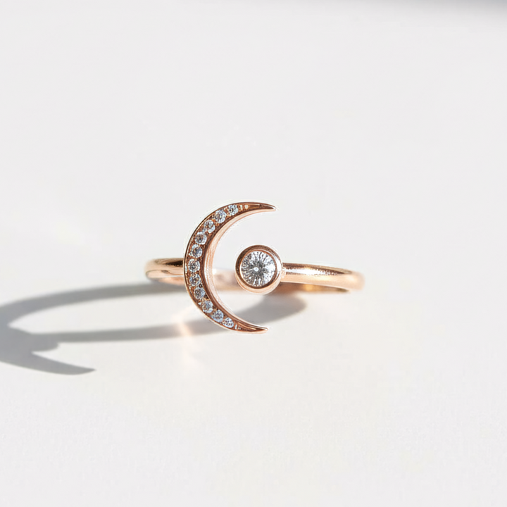 Rose gold ring with a diamond in the center on a light gray background