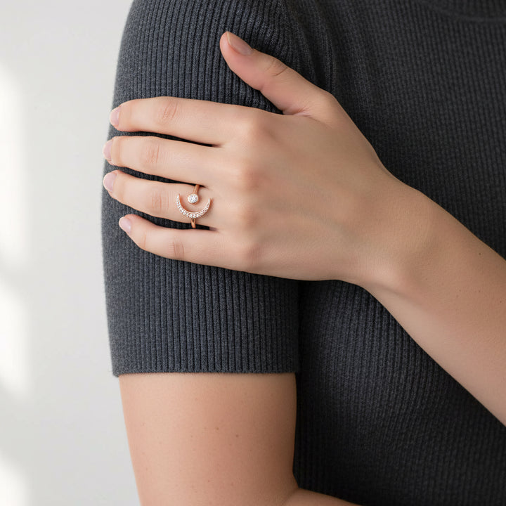Person wearing a gold ring on a plain background