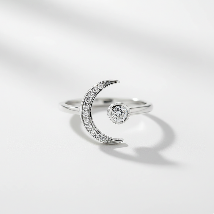 Silver ring with a crescent moon design on a light gray background