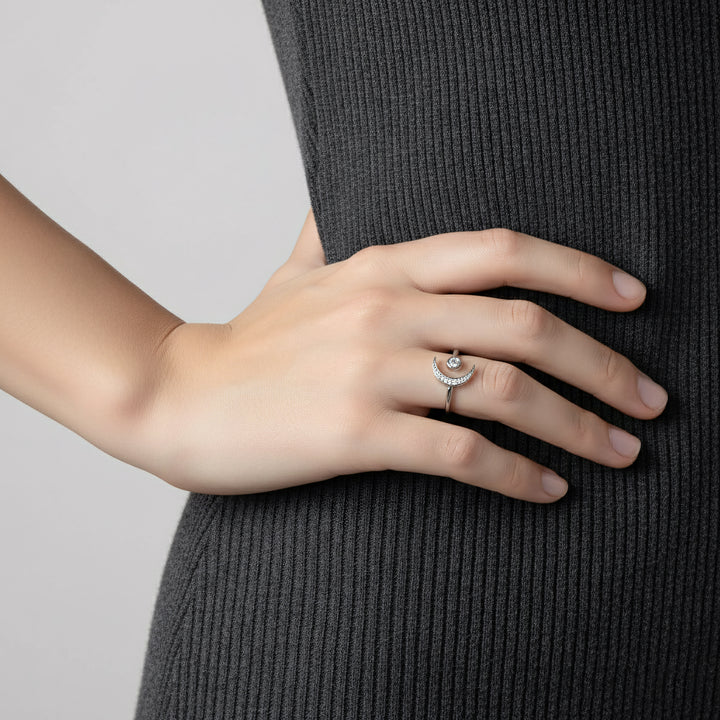 Hand wearing a silver ring with a gray background