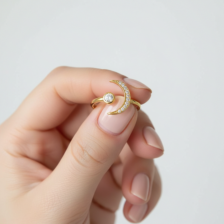 Gold ring with a diamond held between fingers against a light background