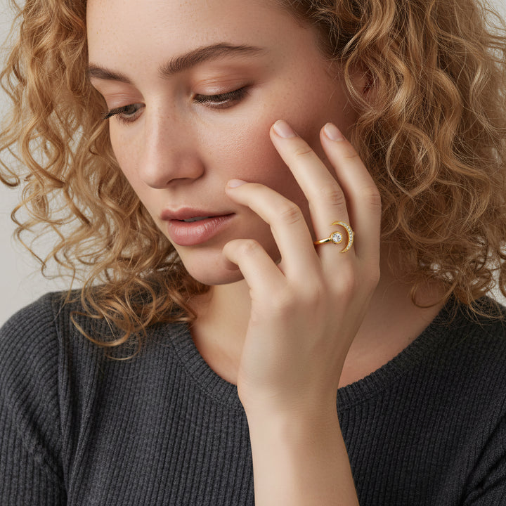 Woman wearing a gold ring, close-up of face and hand