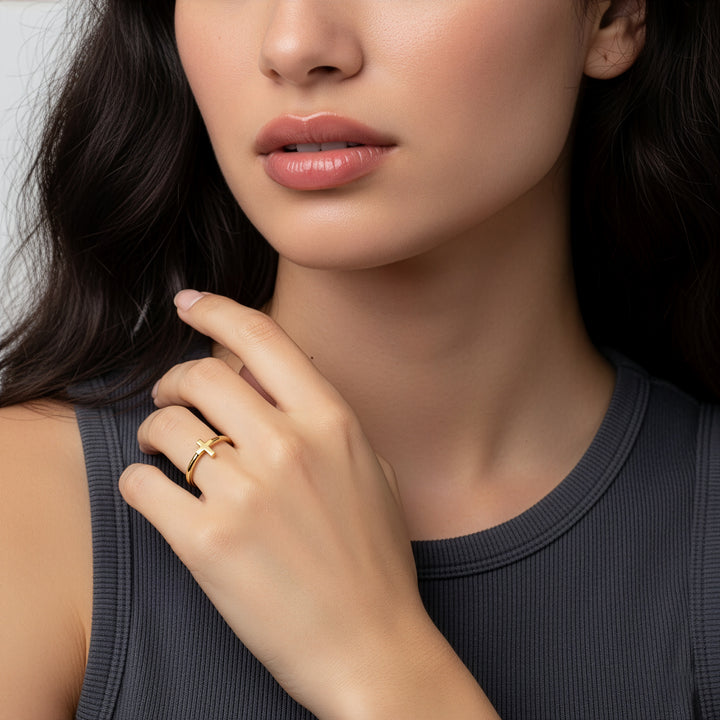 Close-up of a woman wearing a gold ring on her finger.