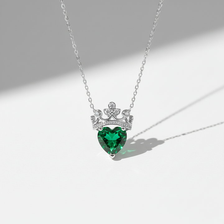 Silver necklace with a heart-shaped green gemstone pendant on a white background