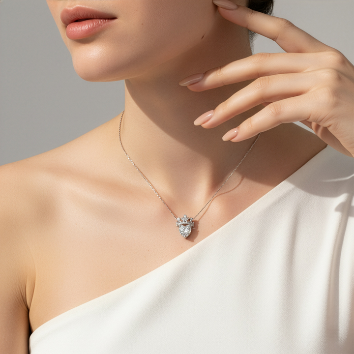 Woman wearing a delicate necklace with a heart-shaped pendant against a neutral background