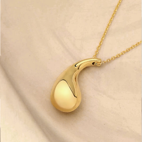 Gold pendant necklace on a beige fabric background