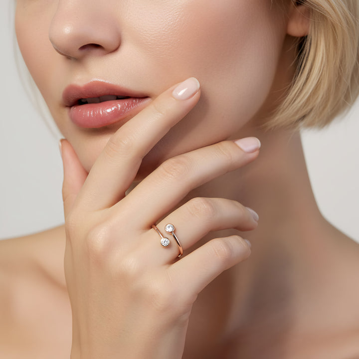 Close-up of a woman's hand wearing a diamond ring with a neutral background