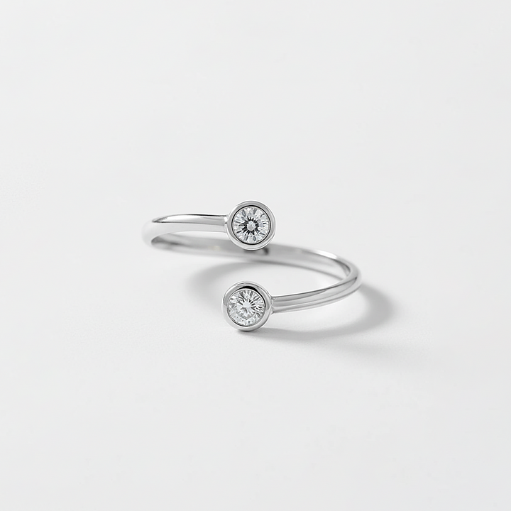 Silver ring with two diamond stones on a light gray background