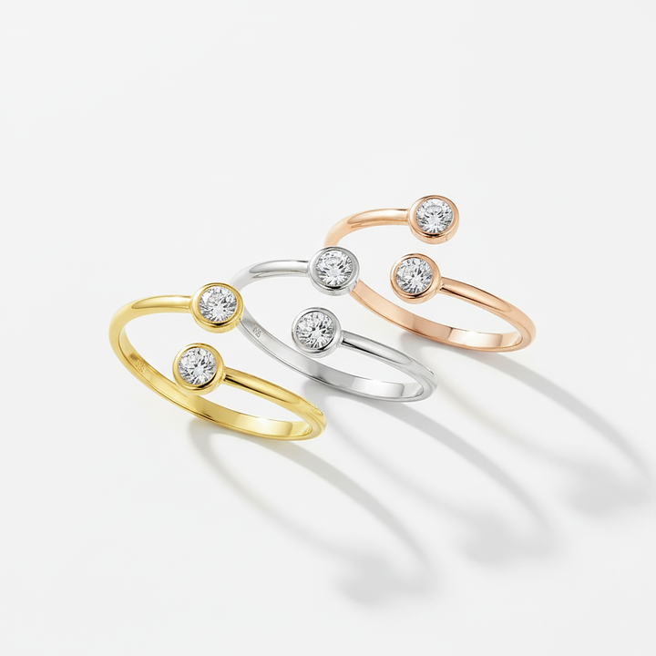 Three open gold, silver, and rose gold rings with small diamonds on a white background