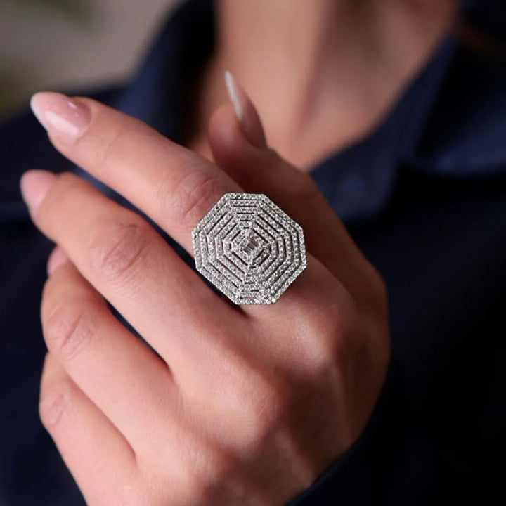 Close-up of a hand wearing a diamond ring with a dark background