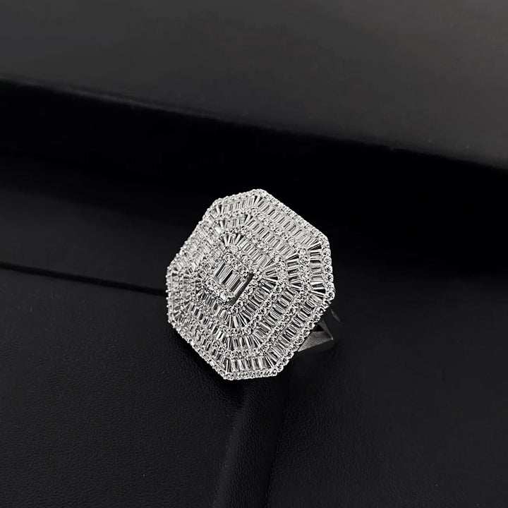 Silver ring with intricate design on a black background