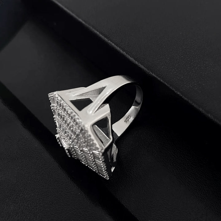 Silver ring with geometric design on a black background