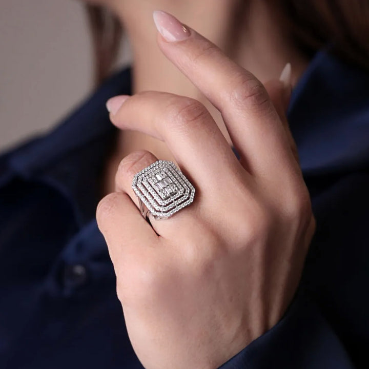 Close-up of a hand wearing a diamond ring with a blurred background
