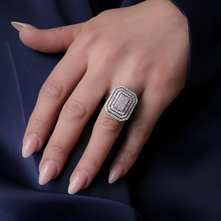 Hand wearing a diamond ring on a dark fabric background