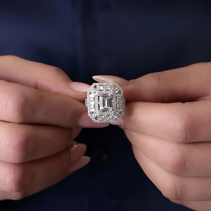 Close-up of hands holding a diamond ring against a dark background