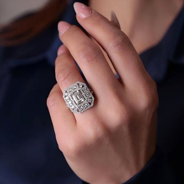 Close-up of a hand wearing a diamond ring with a dark background