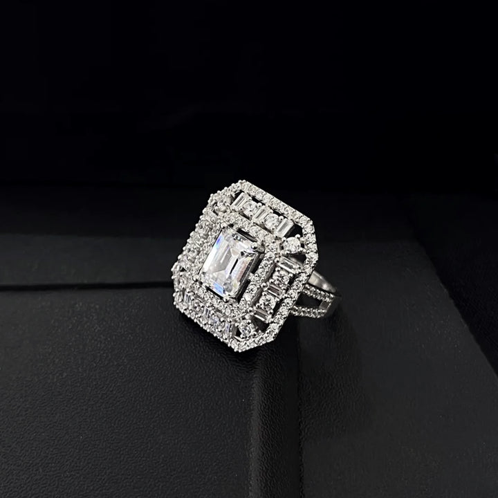 Diamond ring with a rectangular center stone on a black background