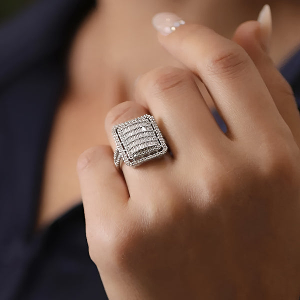 Close-up of a hand wearing a silver ring with gemstones.