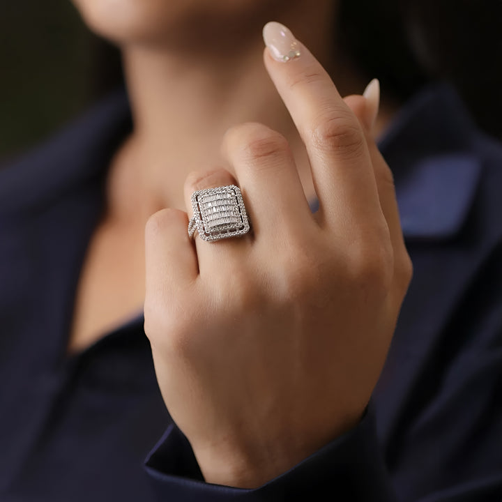 Close-up of a hand wearing a diamond ring with a blurred background