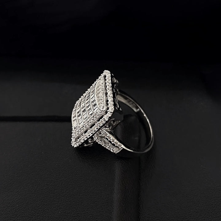 Silver ring with intricate design on a black background