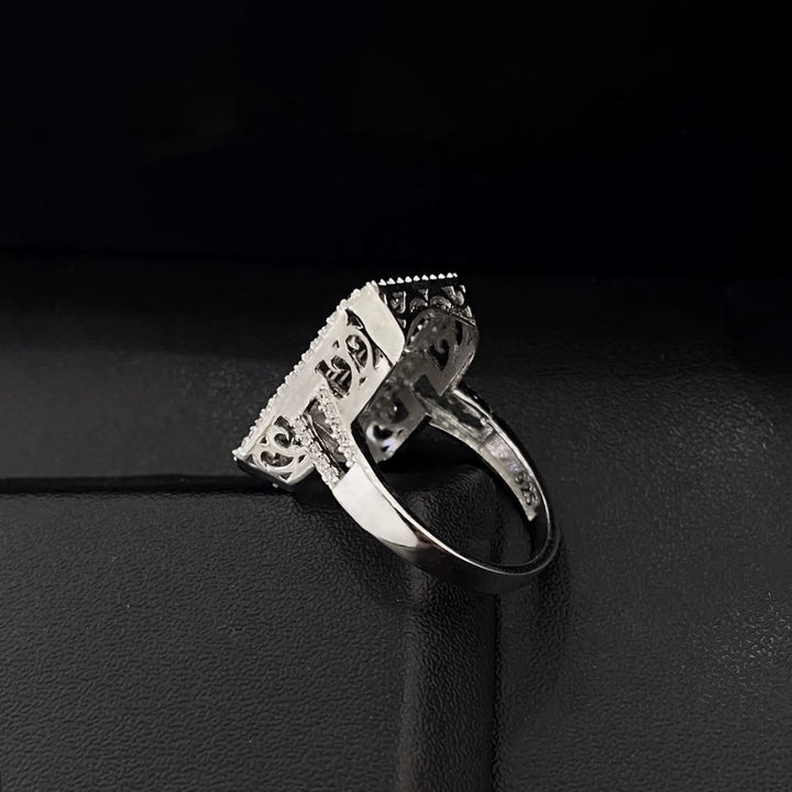 Silver ring with intricate design on a black background