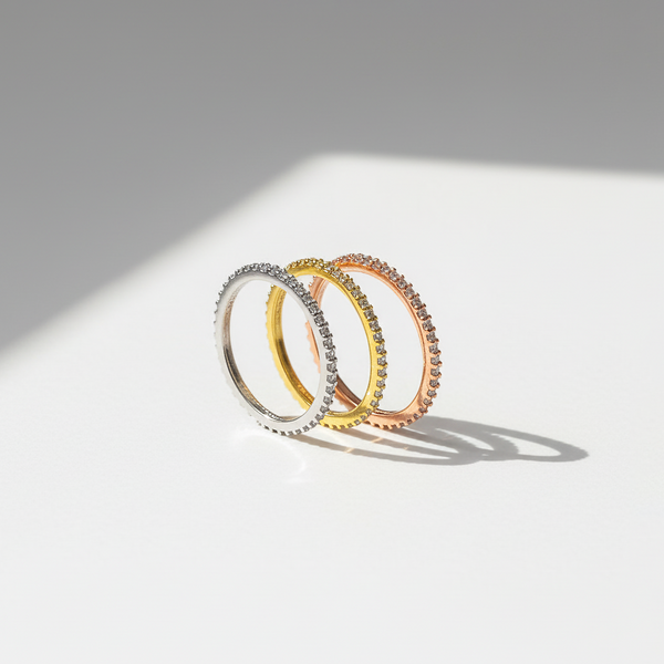 Three rings in silver, gold, and rose gold on a light gray background