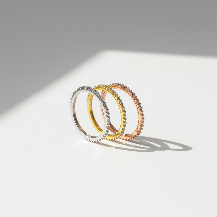 Three rings in silver, gold, and rose gold on a light gray background