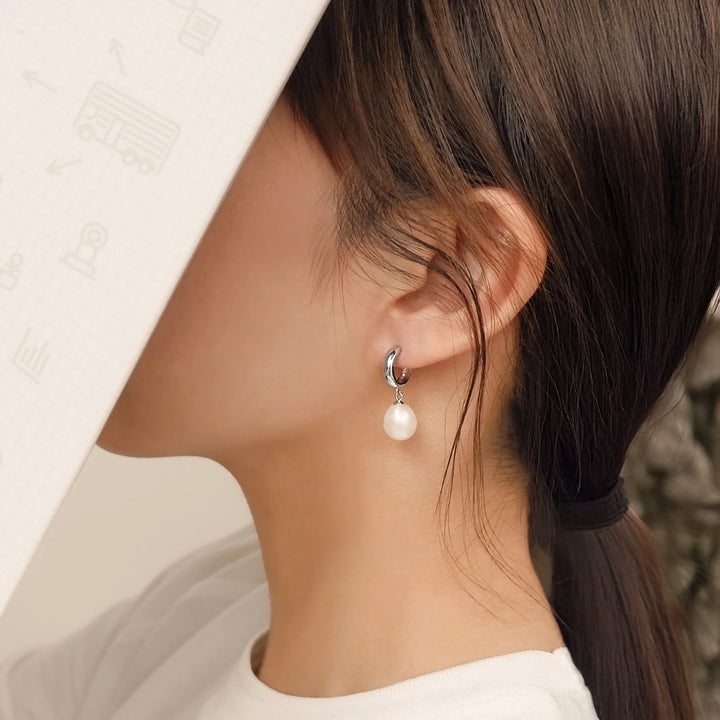 Pearl earring worn by a person with a blurred background