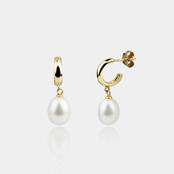 Pair of pearl earrings with gold hooks on a white background
