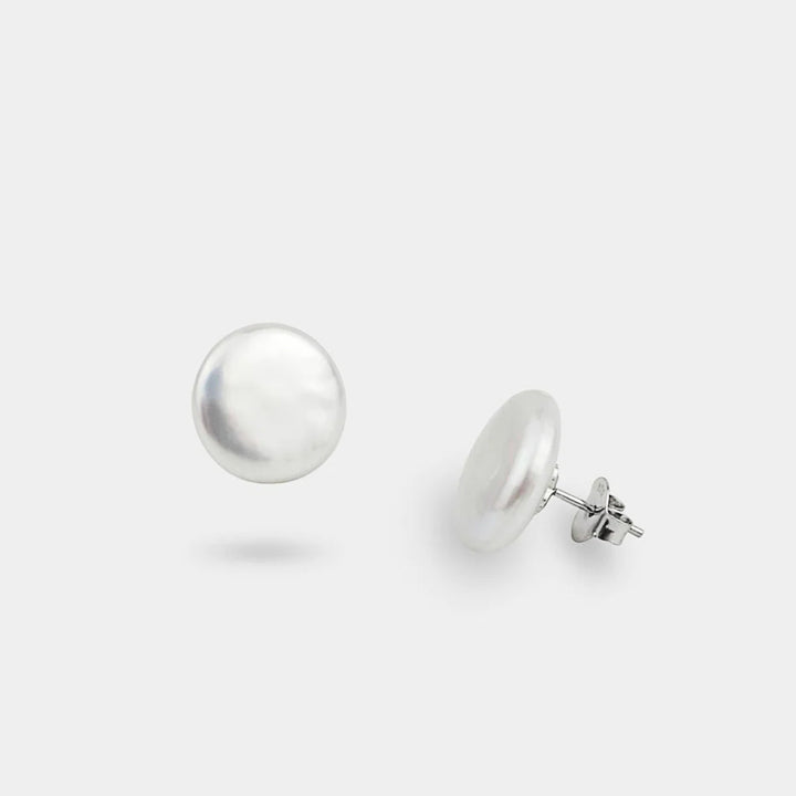 Pair of silver stud earrings on a white background