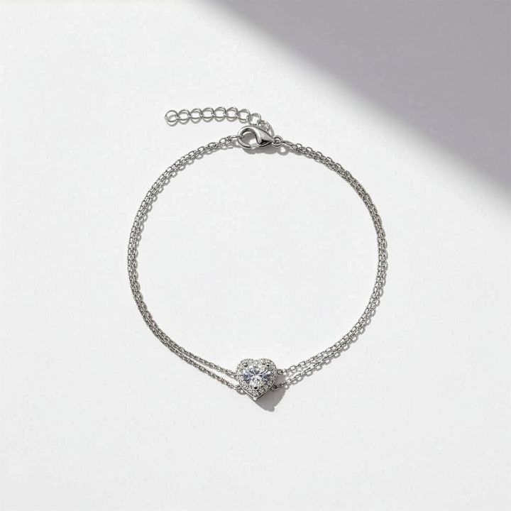 Silver bracelet with a heart-shaped clasp on a light gray background