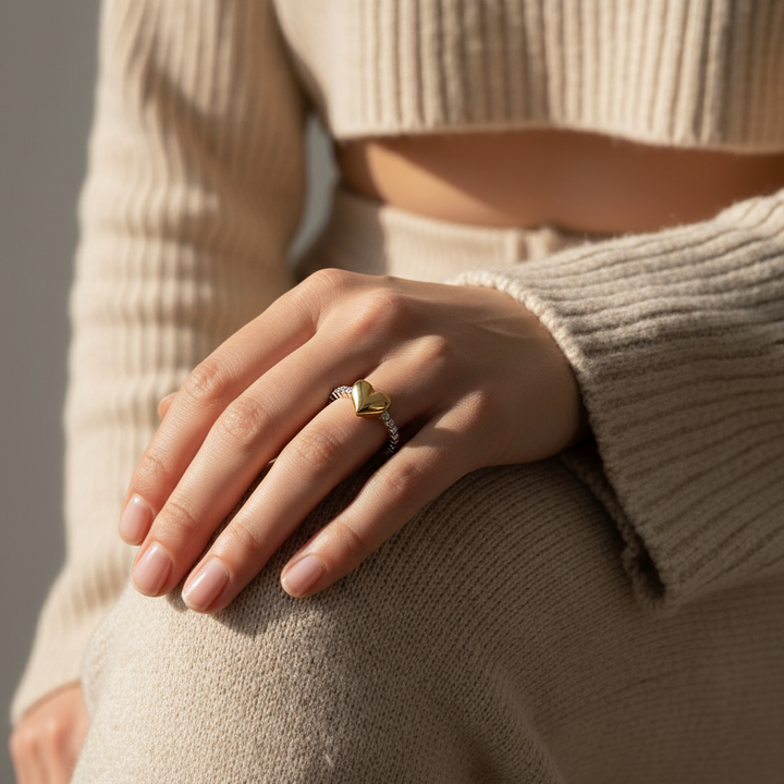 Close-up of a hand wearing a gold ring with a neutral background