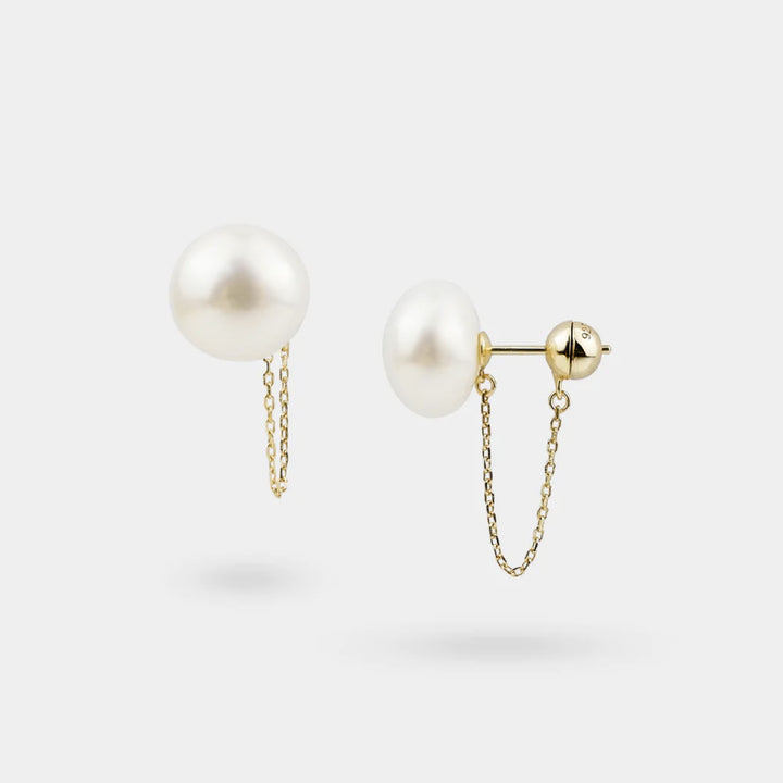 Pearl earrings with gold chains on a white background