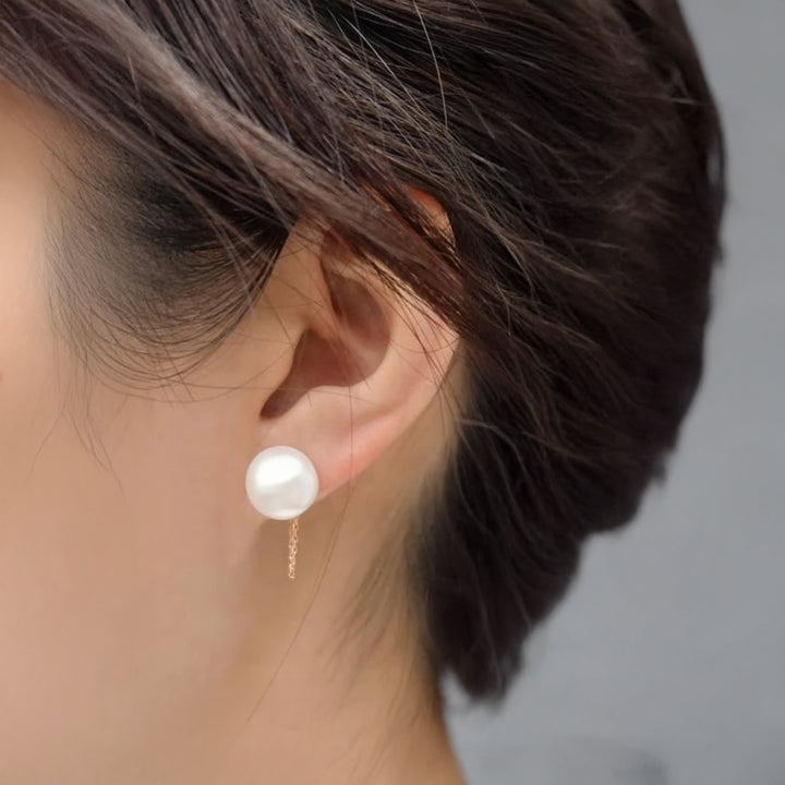 Pearl earring worn by a person with a neutral background