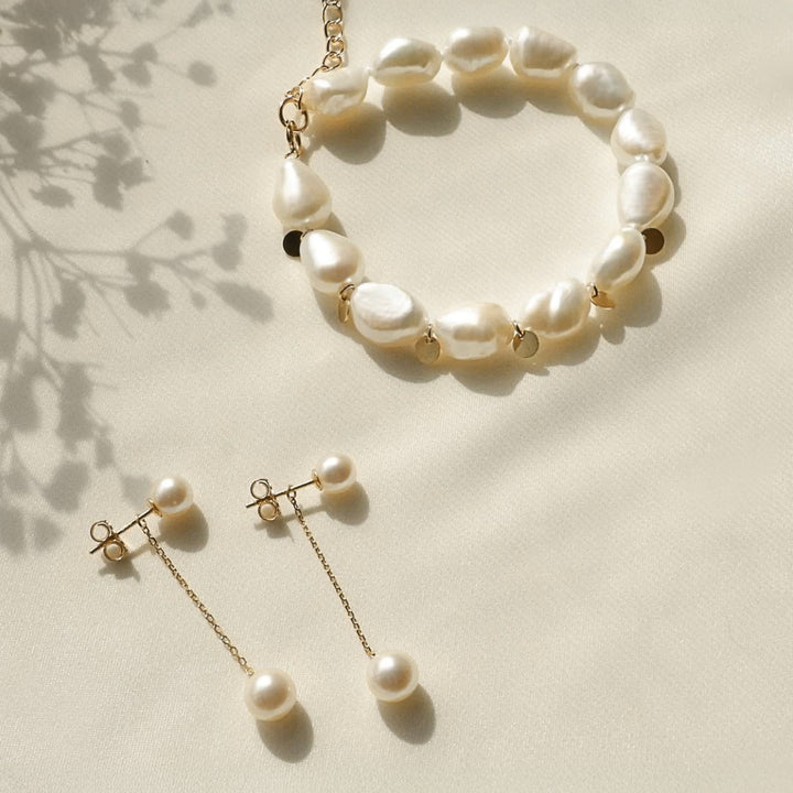 Pearl bracelet and earrings on a light background