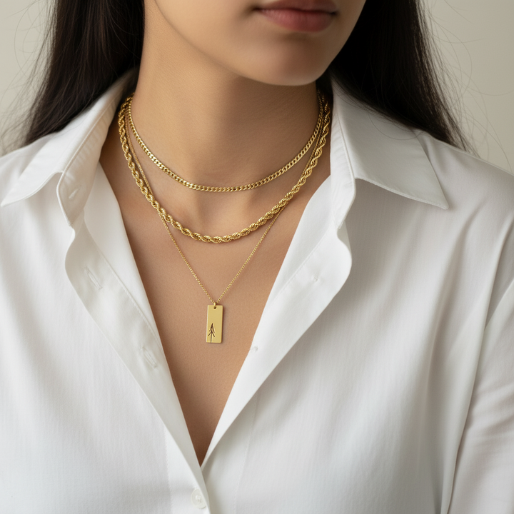 Person wearing a white shirt with gold necklaces