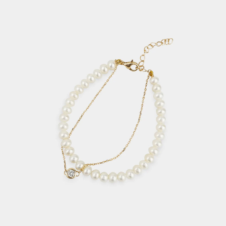 Pearl bracelet with gold clasp on a white background